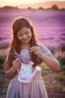 Girl collecting lavender in watering can — Stock Photo