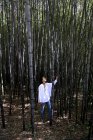 Mulher em pé em uma floresta de bambu — Fotografia de Stock