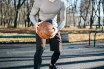 Man playing basketball in park, Minsk, Belarus - foto de stock