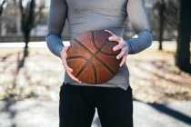 Крупним планом чоловік в парку тримає баскетбол — стокове фото