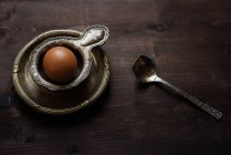 Huevo en una taza de huevo vintage, vista de cerca - foto de stock