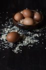 Closeup view of eggs in a wooden bowl with sawdust — Stock Photo