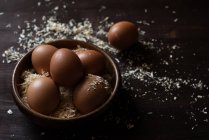 Крупный план яиц в деревянной чаше с опилками — стоковое фото