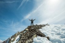 Homme debout sur le sommet de la montagne les bras tendus, chamonix, france — Photo de stock