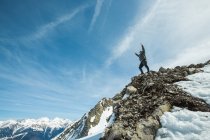 Чоловік стоїть на вершині гори з витягнутими руками, Шамоні (Франція). — стокове фото