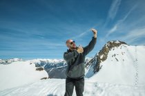 Mann steht auf Berggipfel und macht ein Selfie, Chamonix, Frankreich — Stockfoto