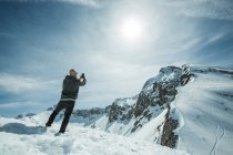 Чоловік, що стоїть на вершині гори, фотографує Чамоні (Франція). — стокове фото