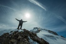 Чоловік стоїть на вершині гори з витягнутими руками, Шамоні (Франція). — стокове фото
