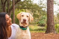 Woman sitting in forest with a dog, Saint Petersburg, Florida, America, USA — Stock Photo