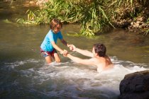 Father and son playing in a river — Stock Photo