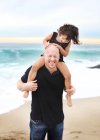 Daughter sitting on father's shoulders — Stock Photo