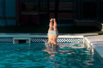Girl diving into a swimming pool — Stock Photo