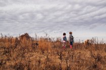 Zwei Kinder stehen auf einem Feld — Stockfoto