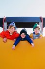 Троє хлопчиків грають на дитячому майданчику — стокове фото