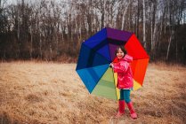 Дівчина тримає різнокольорову парасольку — стокове фото