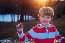 Retrato de um menino sorridente na floresta ao pôr-do-sol — Fotografia de Stock