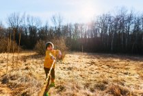 Хлопчик грає з палицею в лісі — стокове фото