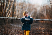 Adorable little boy playing alone in autumnal forest — Stock Photo