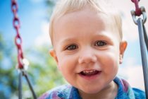 Porträt eines lächelnden Jungen auf einer Schaukel — Stockfoto