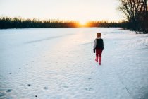 Niño caminando sobre un río congelado - foto de stock