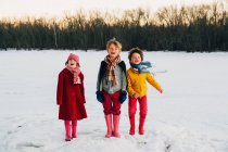 Trois enfants debout dans la neige — Photo de stock