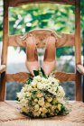 Buquê de casamento e sapatos de noiva em uma cadeira — Fotografia de Stock