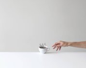 Mão chegando para uma xícara conceitual de café — Fotografia de Stock