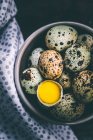 Quail eggs in a bowl with an egg yolk — Stock Photo