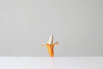 Plátano conceptual en una piel naranja - foto de stock