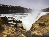 Visão traseira do homem olhando para a cachoeira Gulfoss, Islândia — Fotografia de Stock