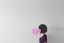 Женщина надувает пузырь жевательной резинки — стоковое фото