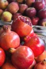 Крупный план гранатов и яблок на продовольственном рынке — стоковое фото