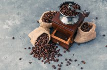 Кавомолка з мішками кавових зерен — стокове фото