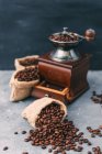 Кавомолка з мішками кавових зерен — стокове фото