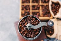 Boîte en bois avec grains de café et moulin à café — Photo de stock