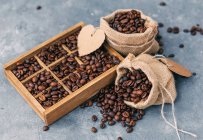 Крупним планом кавомолка і коробка з кавових зерен — стокове фото
