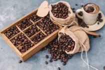 Wooden box and sacks with coffee beans — Stock Photo