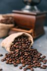 Крупный план кофемолки и мешков кофейных зерен — стоковое фото