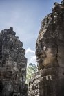 Vista panorámica de las cabezas de piedra esculpidas en el templo de Bayon, Angkor Wat, Siem Reap, Camboya - foto de stock