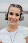 Porträt einer lächelnden Frau mit spitzem Kopfhörer — Stockfoto