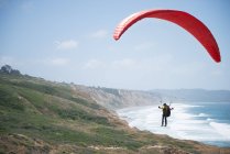 Man paragliding over coastline, La Jolla, California, America, USA — стокове фото