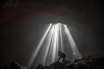 Silhouette of a man taking a photograph, Jomblang cave, Central Java, Indonesia — стокове фото
