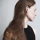 Retrato de uma mulher bonita com cabelos longos olhando para os lados — Fotografia de Stock
