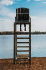 Дівчина сидить на рятувальному стільці з видом на озеро — стокове фото