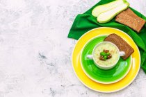Soupe de courgettes savoureuse avec pain de seigle, vue surélevée — Photo de stock