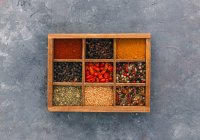 Herbes et épices dans une boîte en bois sur fond rustique — Photo de stock