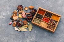 Herbes et épices dans une boîte en bois sur une surface rustique — Photo de stock