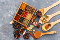Herbs and Spices in a wooden box wih spoons — Stock Photo