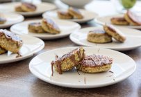 Banana pancakes with chocolate spread on white plates, served table — Stock Photo