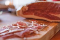 Close-up view of cured ham on chopping board — Stock Photo